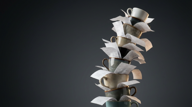 Bodegón elegante con una torre inestable de tazas de café expreso sobre una base de recibos de papel.